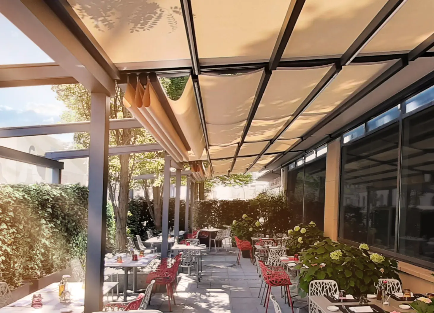 Lachsfarbene Pergola-Markise über einer Terrasse mit mehreren Tischen